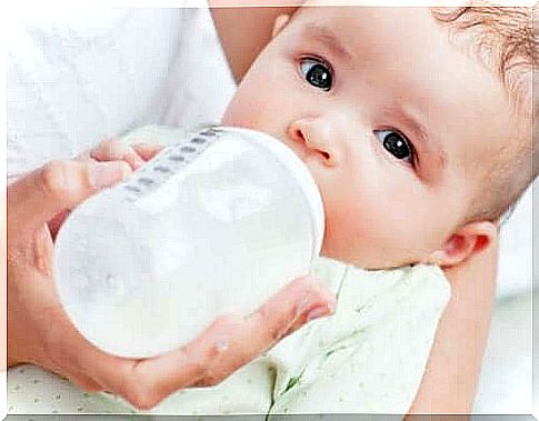 the baby drinks from a feeding bottle